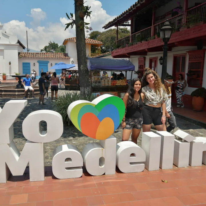 Dos mujeres junto al letrero de yo amo a Medellín. 