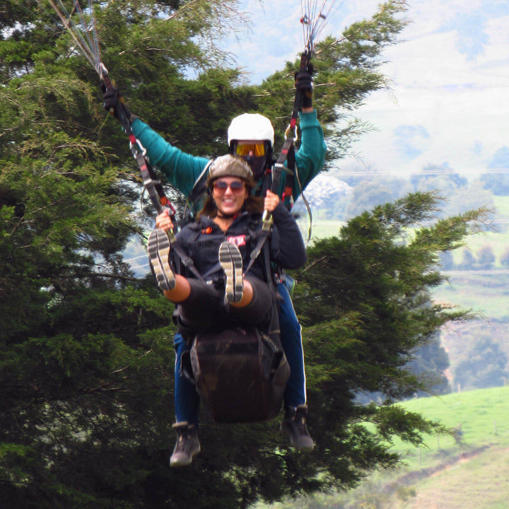 Dos personas volando en parapente.